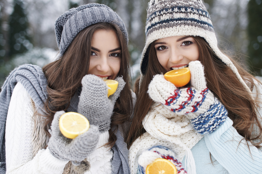 Женщины едят апельсины