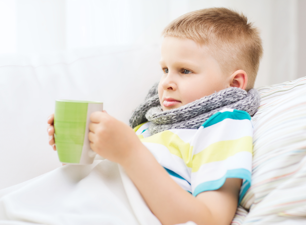 Ребенок пьет напиток от простуды и гриппа