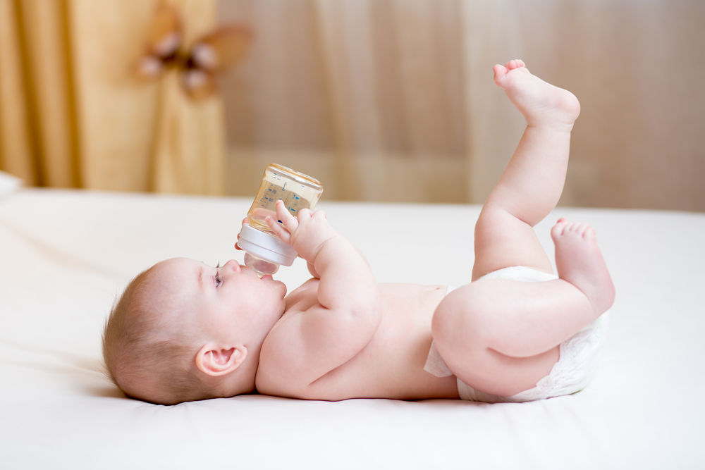 Малыш пьет воду из бутылочки