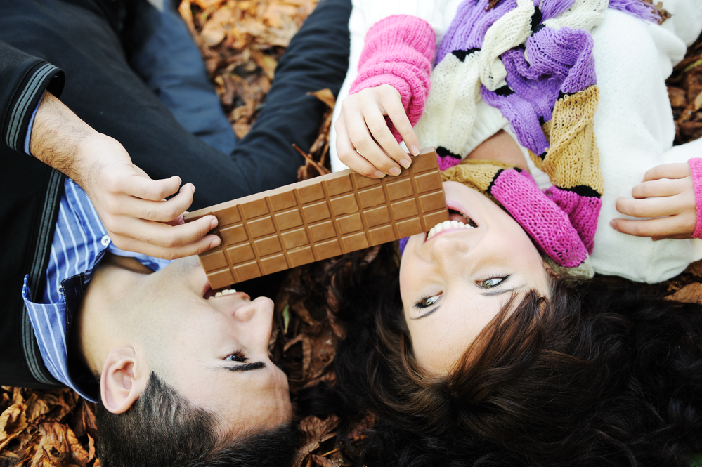 Пара їсть шоколад в парку