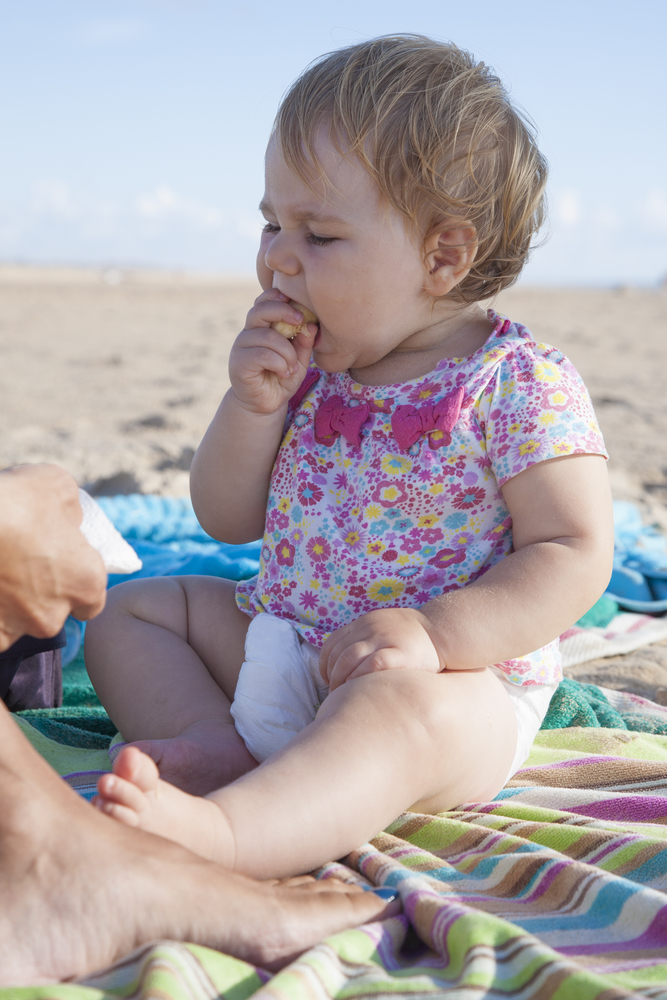 Ребенок ест на пляже