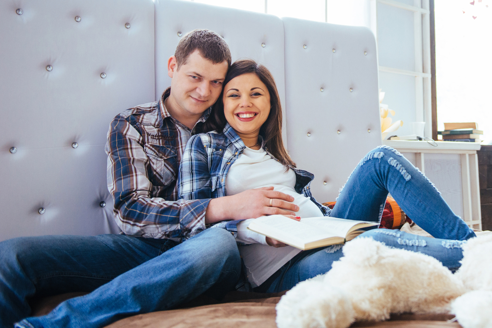 Беременная с мужем читают книгу