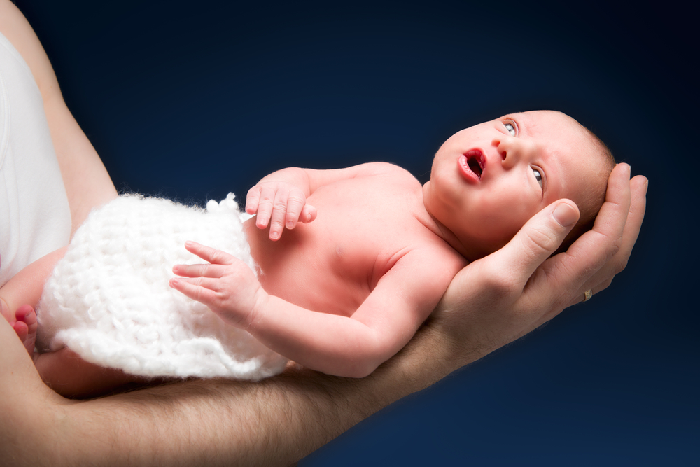 Папа держит новорожденного одной рукой