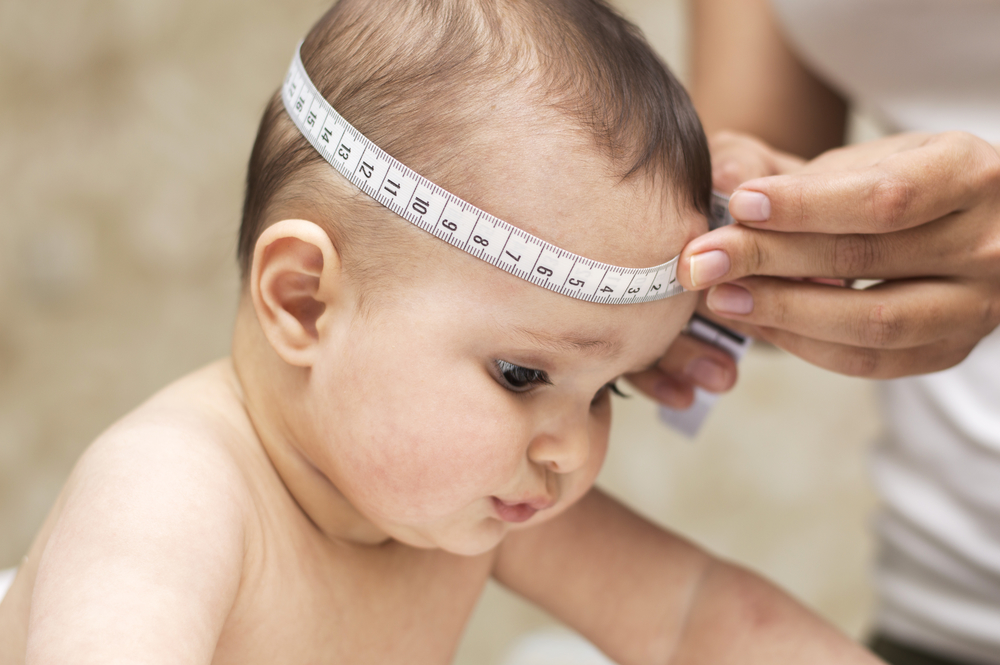 Ребенку измеряют сантиметром голову
