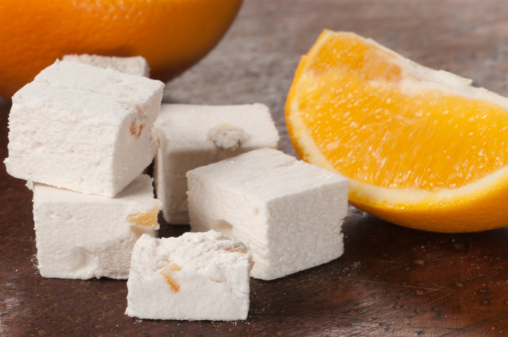 Полезные сладости: лукум на столе  с кусочком апельсина
