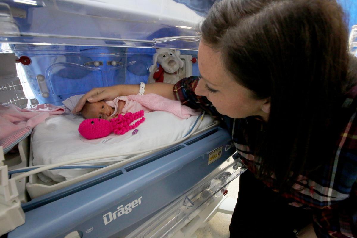 Недоношений малюк в інкубаторі з іграшкою