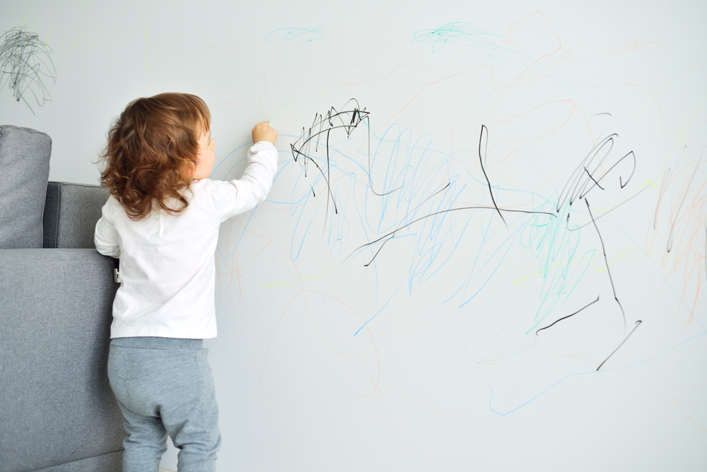 ​Малюк малює на стіні