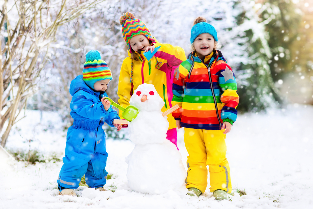 Дети лепят снеговика зимой