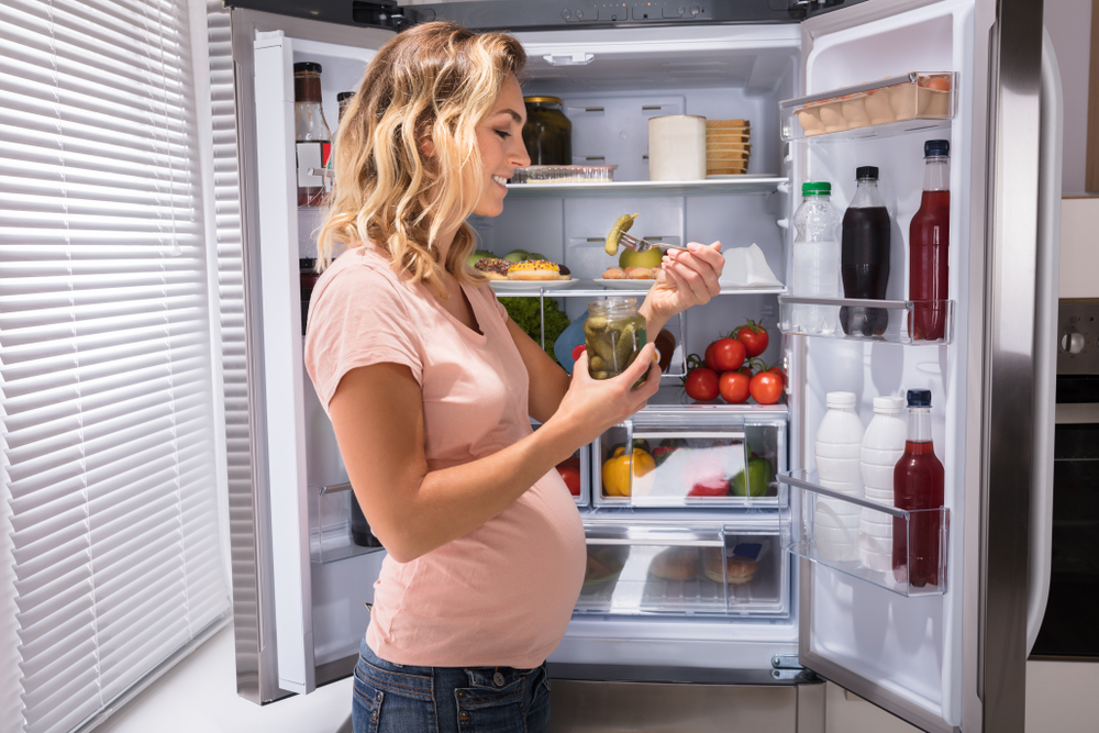 Беременная возле холодильника